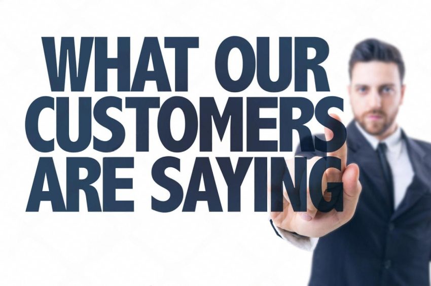 Business person pointing at the words What Our Customers Are Saying, illustrating customer experience feedback